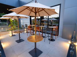a restaurant with tables and chairs with umbrellas at ibis Barra do Garças in Barra do Garças
