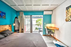 a bedroom with a bed and a desk and a window at Beachfront Studio in Marigot in Marigot