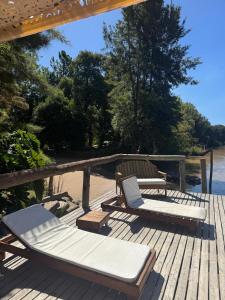 two lounge chairs and a table on a wooden deck at Cabañas Allende Delta in Tigre