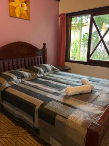 a bed with two pillows on it in a bedroom at Mato Verde Hospedaria - À beira da Lagoa - Praia do Rosa in Imbituba +16 photos