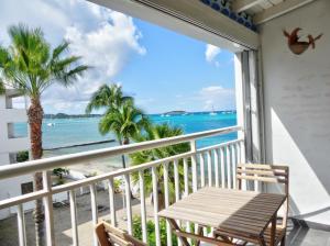 a balcony with a table and a view of the ocean at Beachfront Studio in Marigot in Marigot
