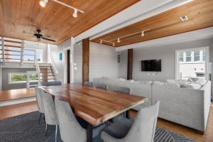 a dining room with a wooden table and a couch at Crabcake Village OBX in Salvo