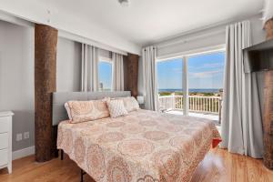 a bedroom with a bed with a view of the ocean at Crabcake Village OBX in Salvo +37 photos
