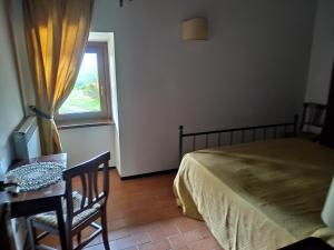 a bedroom with a bed and a table and a window at Agriturismo Il Conventino in Vallicchio