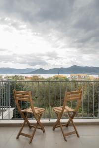 two chairs sitting on a balcony with a view at DION APARTMENTS in Paleros