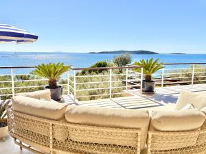 a large wicker couch sitting on a balcony overlooking the ocean at Villa Tempera in Vis