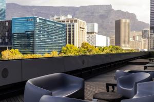a balcony with chairs and a view of a city at Onyx Studio Apartment in Cape Town