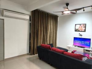 a living room with a couch and a flat screen tv at Atabara ECRL Stay Homestay in Kuantan +5 photos