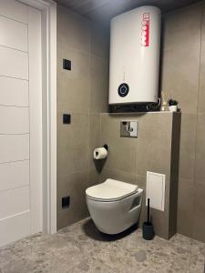 a bathroom with a toilet and a tv on the wall at Uduaasa Minimaja in Urge