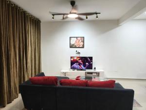 a living room with a couch and a flat screen tv at Atabara ECRL Stay Homestay in Kuantan