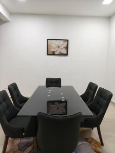 a conference room with a black table and chairs at Atabara ECRL Stay Homestay in Kuantan
