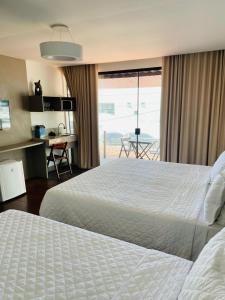 a hotel room with two beds and a view of the ocean at Transcar Suítes in Aracaju