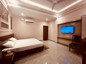 a bedroom with a bed and a flat screen tv at Ram Anandam inn in Ayodhya