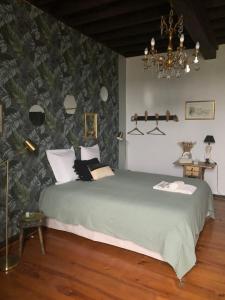 a bedroom with a large green bed with a green leaf wallpaper at L'Horizon de Marianne in Montagnac-sur-Auvignon