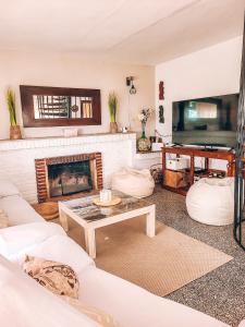 a living room with a fireplace and a table at Casa Terra in Hontanar