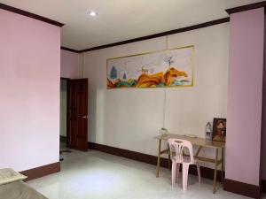 a dining room with a table and a pink chair at FUBON World Hostel in Ban That-Louang
