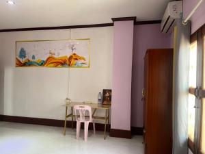 a dining room with a table and two pink chairs at FUBON World Hostel in Ban That-Louang +43 photos