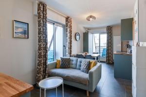 a living room with a couch and a table at 2 Chambres - 150m plage - Centre & Marché 50m - Parking - Linge & Menage inclus in Houlgate