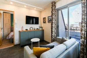 a living room with a couch and a tv at 2 Chambres - 150m plage - Centre & Marché 50m - Parking - Linge & Menage inclus in Houlgate