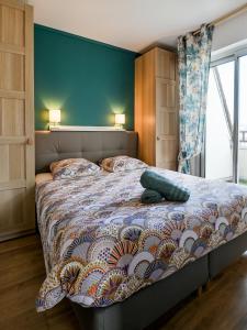 a bedroom with a large bed with a blue wall at 2 Chambres - 150m plage - Centre & Marché 50m - Parking - Linge & Menage inclus in Houlgate
