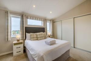 a bedroom with a large white bed and windows at Primrose 2 bed-No Pets-Daisy in Eye