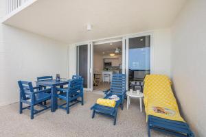 a dining room with blue chairs and a table and a couch at Apollo 207 in Marco Island