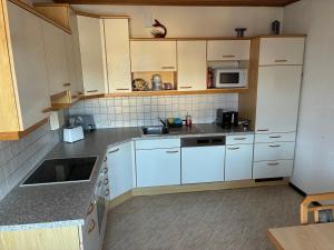 a kitchen with white cabinets and white appliances at Chill out Zone in Kraubath an der Mur