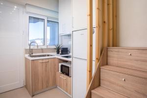 a kitchen with a white refrigerator and a sink at Charaki Rest Point in Haraki