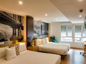 a hotel room with two beds and a couch at Hospedaje Boutique Weber's in Gijón +47 photos