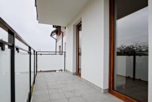 a hallway of a building with glass doors and a balcony at Apartament Różany 2 in Busko-Zdrój