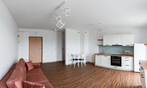a living room with a couch and a kitchen at Apartament Różany 2 in Busko-Zdrój