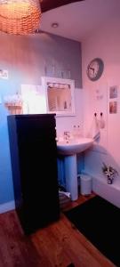 a bathroom with a sink and a clock on the wall at Chez ISA chambre chez l'habitant Léa in Montlouis-sur-Loire +15 photos