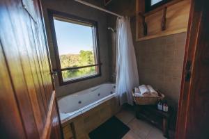 a bathroom with a bath tub and a window at Tacuapí Lodge in Aristóbulo del Valle +44 photos