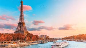 a view of the eiffel tower and a river with boats at Studio élégant en RDC, confort et simplicité in Vaires-sur-Marne +6 photos