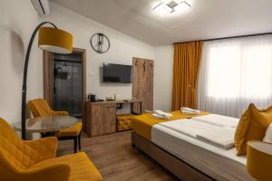 a hotel room with a bed and a table and a tv at Hotel Domestika in Skopje
