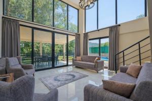 a living room with two couches and glass windows at Villa Ana in Kızılyurd
