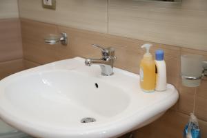 a bathroom sink with two bottles of soap on it at Apartment Nikolas Berat in Berat