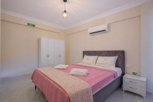 a bedroom with a large bed with a pink blanket at Villa Ana in Kızılyurd