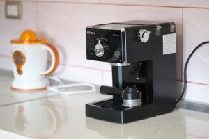 a black coffee maker on a counter with a cup at Apartment Nikolas Berat in Berat +12 photos