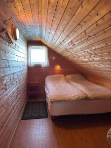 a bed in a room with a wooden ceiling at Lysbøen Bua in Ramberg