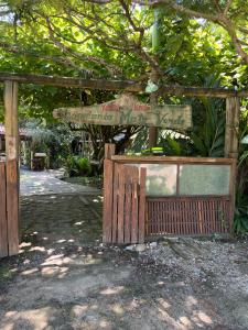a wooden gate with a sign for a garden at Mato Verde Hospedaria - À beira da Lagoa - Praia do Rosa in Imbituba