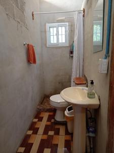 a bathroom with a toilet and a sink at Ranchito Cornejo in La Esmeralda