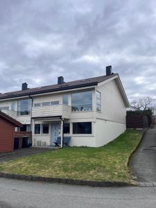 a white house with large windows on a street at 2 minute walk from ONS exhibiton area in Stavanger