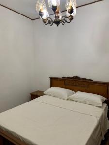 a bedroom with a white bed with a chandelier at La casa di Amina in Rome