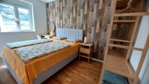 a bedroom with a bed with a wooden wall at My Life 19 - Green Hill in Soko Banja