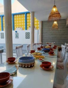 a dining room with a long table with dishes on it at Dar morjana in Chott Meriem