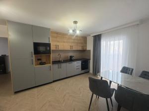 a kitchen with a table and a dining room at Borșa ApartHotel 5 in Borşa