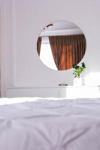 a bedroom with a white bed and a mirror at Ghetto Experience - Self Check-In - Usa cu Cod in Vaslui +5 photos