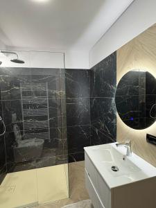 a bathroom with a sink and a mirror at Borșa ApartHotel 5 in Borşa
