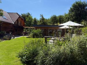 a house with an outdoor patio and an umbrella at Za kovárnou in Zděchov